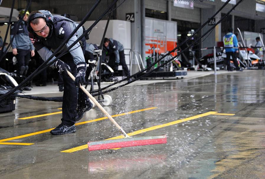 I meccanici tolgono l&#39;acqua in eccesso dalla pit lane: la pioggia è stata proprio la chiave della gara. EPA